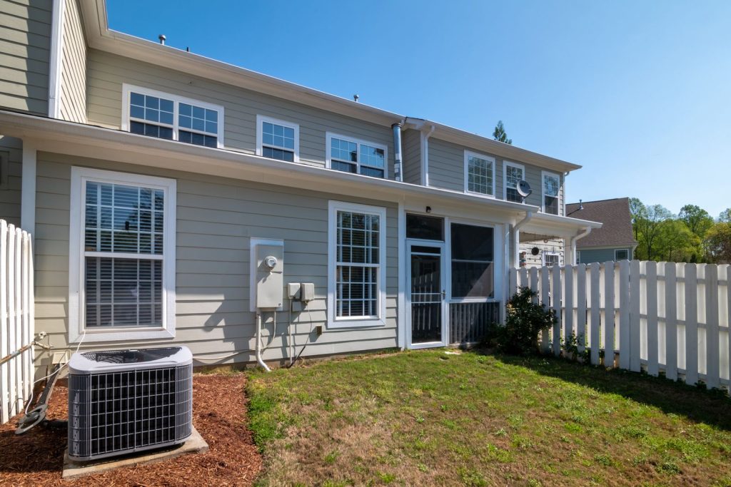 Outdoor air conditioner condenser next to a residential home