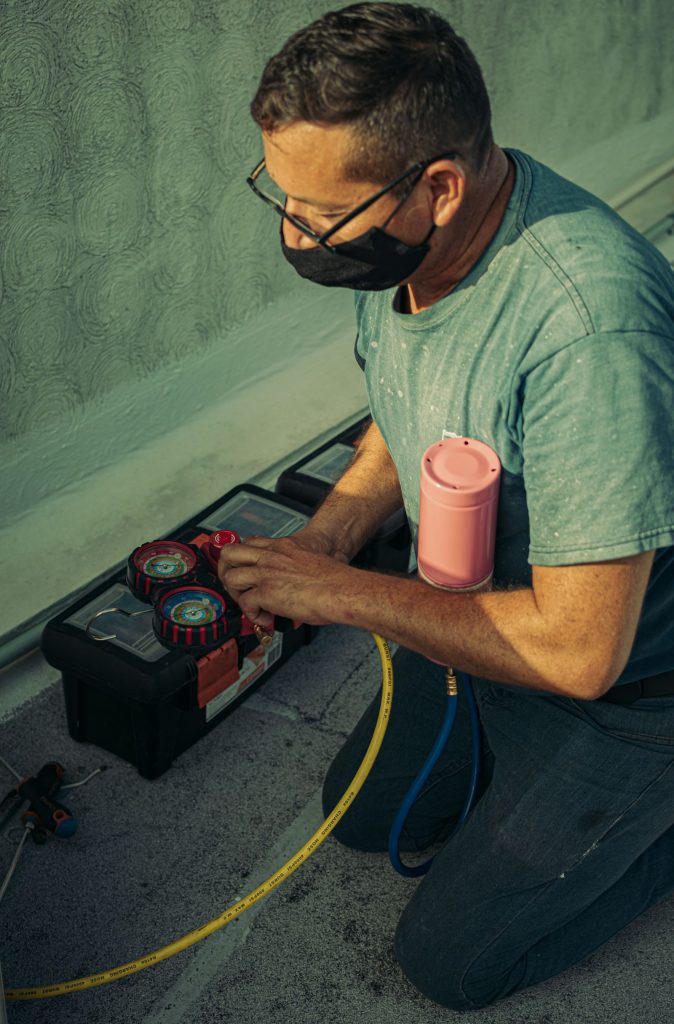 Outdoor AC unit being serviced by a technician