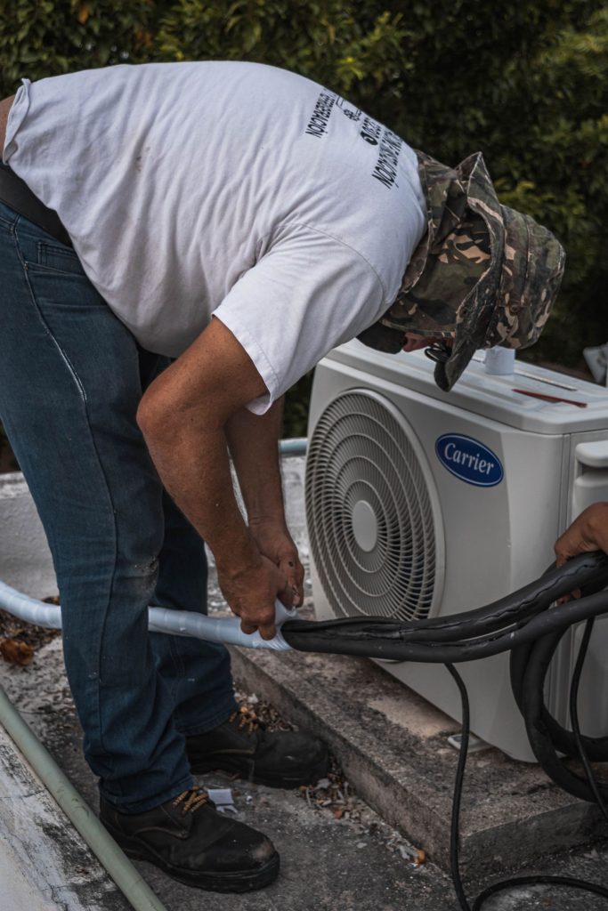 Technician working on an outdoor air conditioning unit